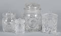 Four colorless glass lidded canisters