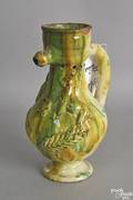 Redware puzzle jug with applied leaf and horse decoration with yellow and green glaze