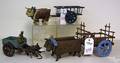 Three carved and painted oxen and wagons