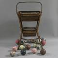 Fifteen Victorian Porcelain Carpet Balls Displayed on a Twotier Woven Rattan Stand