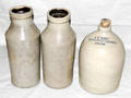 0497 CROCKERY JUG AND TWO CYLINDER FORM BOTTLES H 10 3