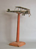 Folk art tin biplane model and stand