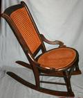 010515 AMERICAN ANTIQUE WOOD AND CANE ROCKING CHAIR