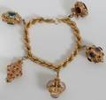 062097 14KT GOLD CHARM BRACELET 66 GRAMS