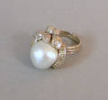14K white gold pearl and diamond ring with center 13 mm baroque pearl surrounded by floral decoration encrusted with diamonds