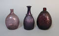 Three blown amethyst glass bottles