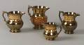 Four Copper Lustre Earthenware Pitchers