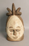 Carved African helmet mask with a white painted face