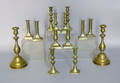 Seven pair of brass candlesticks