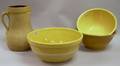 Three Large Banded Yellowware Mixing Bowls and a Stoneware Batter Pitcher