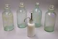 Four Aqua Glass Pharmacy Jars and an Opaque Glass Pump Container