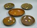 Four Redware Plates and an Oval Glazed Dish