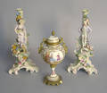 Pair of German porcelain figural candlesticks together with a covered urn