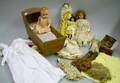 Five Assorted Dolls Clothing and a Wooden Cradle