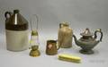 Pewter Teapot a Goldpainted Tin Kerosene Skaters Lantern an Ivorine Brush a Copper Mug and Two Small Ston