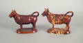 Two Rockingham tortoiseshell glazed pottery cow creamers