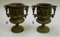 Pair of Cast Metal Putti and Grapevine Decorated Mantel Urns
