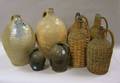 Two Stoneware Jugs Two Glazed Redware Jugs and Four Wicker Wrapped Green Glass Demijohns