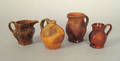 Three miniature redware pitchers and a jug 19th c