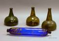 Three Amber and Olive Blown Glass Rum Bottles and a Paint Decorated Cobalt Blown Glass Rolling Pin Whimsy