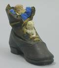 Two Bisque Figures in Leather Shoe