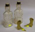 Two Colorless Molded Glass Figural Lincoln Bank Bottles and a Pair of Miniature Brass High Button Shoeform Flo