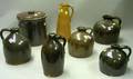 Five Assorted Brown Glazed Stoneware Jugs a Pitcher and a Lidded Crock