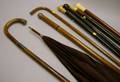 Five Walking Sticks Two Sterling Silver Embellished Canes and a Maroon Silk Parasol