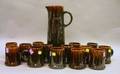 Rockingham Glazed Stoneware Pitcher and a Set of Fourteen Mugs
