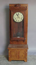Waterbury oak wall clock mounted on a hall seat