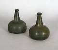Two green glass squat bottles
