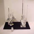 Two Al Aluminum Robot Sculptures together with a Small Model two solid aluminum robots with aluminum antenna swiveling head and smili