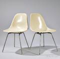 Two Shell Chairs by Charles and Ray Eames manufactured by Herman Miller Zeeland Michigan molded fiberglass and tubular steel ivory