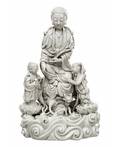A BLANCDECHINE FIGURE OF GUANYIN ON A ROCK WITH TWO ATTENDANTS