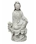 A BLANCDECHINE FIGURE OF GUANYIN ON A ROCK