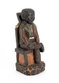 Carved and painted figure of a seated black male
