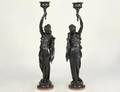 PAIR OF EBONIZED COMPOSITE STONE FIGURAL TORCHIERES