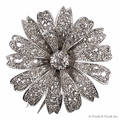 Platinum flower fur broochpendant centered with an old mine cut diamond