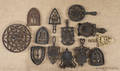 Collection of twelve cast iron trivets