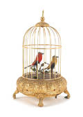Gilt metal bird cage with two singing birds