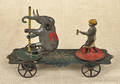 Early American painted tin pull toy with an elephant on a merry go round