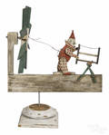 Carved and painted pine whirligig of a clown sawing wood