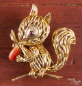 Wire constructed 18K yellow gold squirrel brooch with coral and a ruby eye