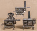 Three cast iron and nickel toy stoves