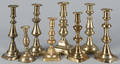 Eight unmatched English brass candlesticks