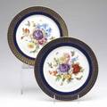 Meissen porcelain two service plates handpainted with floral bouquet and birds and butterflies with gilt rim against a blue ground both marked 10 dia