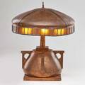 Arts and crafts copper table lamp with domed shade bordered in leaded amber glass and base with four buttressed handles ca 1915 unmarked 19 x 15 12 dia