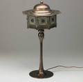 Jugendstil style copperpatinated brass table lamp its faceted shade with copper top and leaded glass panes on a candlestick base unmarked 24 x 11