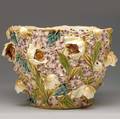 Zsolnay faience jardiniere elaborately decorated with violets and tulips in relief on a reticulated ground covered in majolica glazes a couple of short lines several minor nicks to blossoms brown