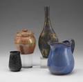 Studio pottery vase covered in copper lustre and gunmetal glaze jar covered in brown glaze small vase with carved tree imagery and pitcher covered in blue glaze provenance collection of hope and